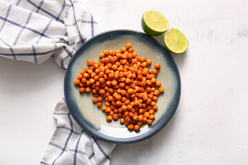 Plate with tasty fried chickpeas and lime on white background