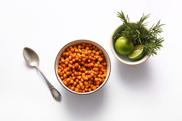 Bowl of tasty fried chickpeas with lime and rosemary on white background