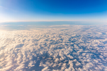 Beautiful orange and pink sunrise over the clouds, view from the plane.