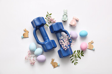 Composition with dumbbells, Easter eggs, decor and flowers on light background