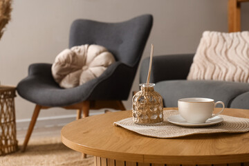 Coffee table with diffuser and cup in living room. Closeup