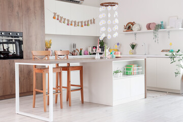 Interior of light kitchen decorated for Easter with table and counters