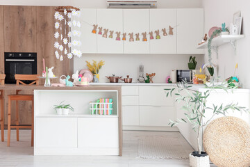 Interior of light kitchen decorated for Easter with table and counters