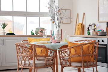 Dining table set for Easter with rabbits and tree branches in kitchen