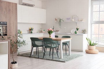 Interior of light kitchen decorated for Easter with dining table and counters