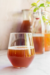 a glass of black tea kombucha fermented probiotic drink on white table.