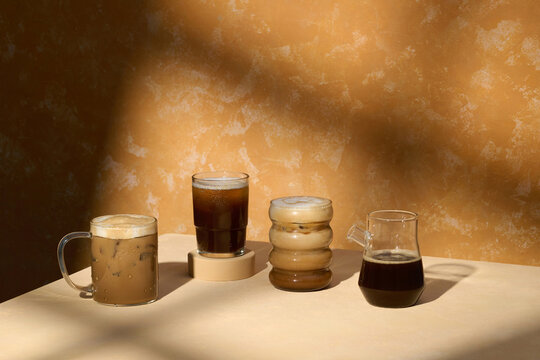 Assorted Iced Coffee Drinks in Stylish Glasses on Textured Surface