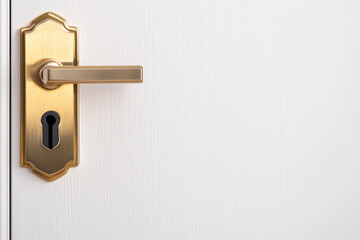 Gold colored door handle with keyhole on white wooden door