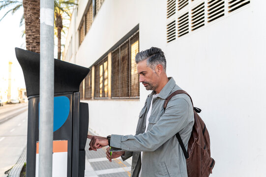 Man paying parking meter with contactless card