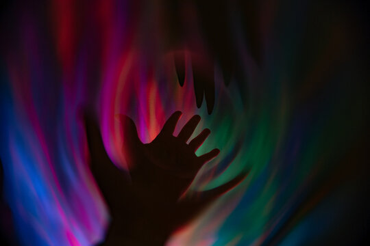 Abstract light display with a shadowed hand reaching out