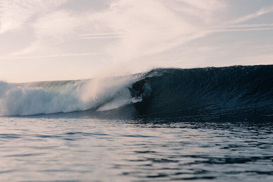 Talented surfer carving the heart of a wave executing a tube ride