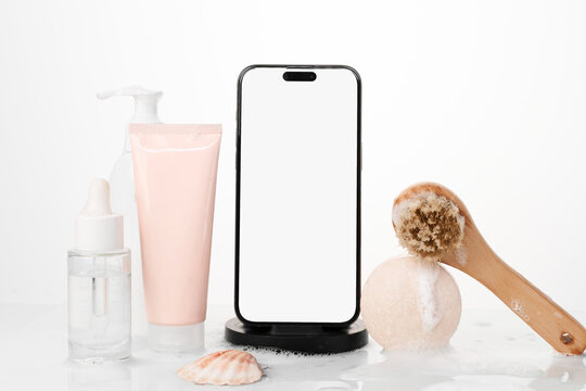 A mobile phone with white screen next to hygiene products