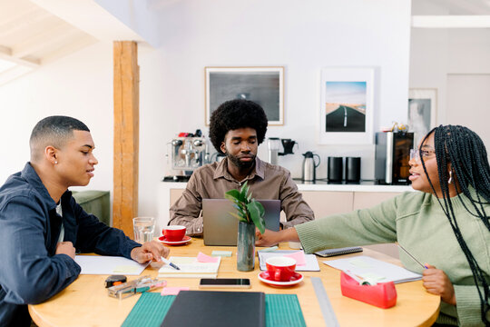 Mid-range shot of three imaginative team members collaborating