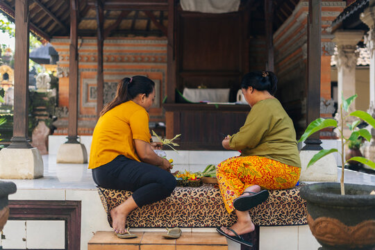 Balinese women preparing Canang Sari offerings in a temple in Bali