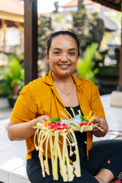 Balinese woman preparing Canang sari, traditional offering