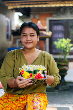 Balinese woman preparing Canang sari, a daily offering in Bali