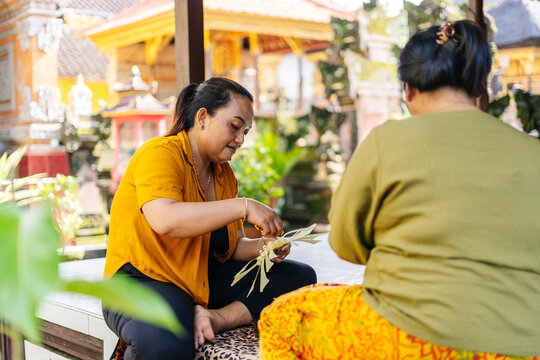 Balinese women preparing Canang sari offerings in Bali, Indonesia