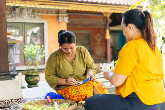 Balinese women preparing Canang sari offerings in Bali, Indonesia