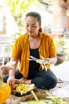 Balinese women preparing Canang sari offerings in Bali, Indonesia