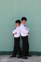 Fototapeta premium 8 and 10 year old Latino children dressed in school uniforms are happy and excited about going back to school