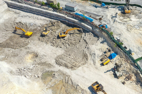five excavators excavating at the construction site
