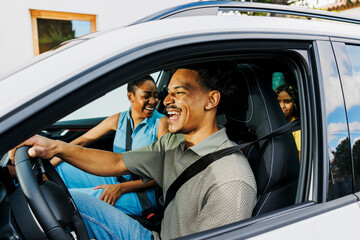 Happy family driving in car enjoying road trip