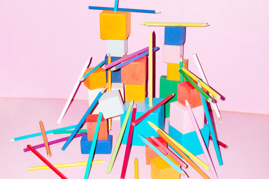 Colourful building blocks cubes on pink background with hard flash