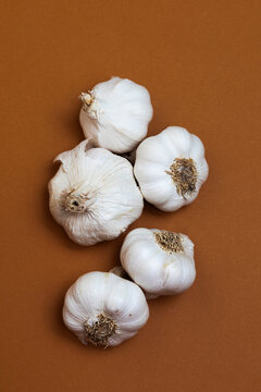 Loose Garlic Bulbs on Brown Surface