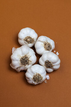 Cluster of Garlic Bulbs on Brown Surface