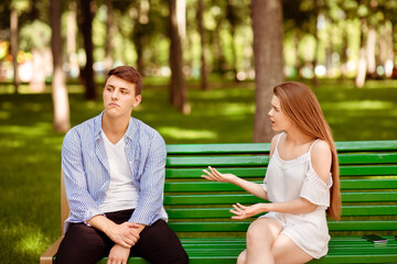 Relationship problems. Millennial couple having argument on bench at city park