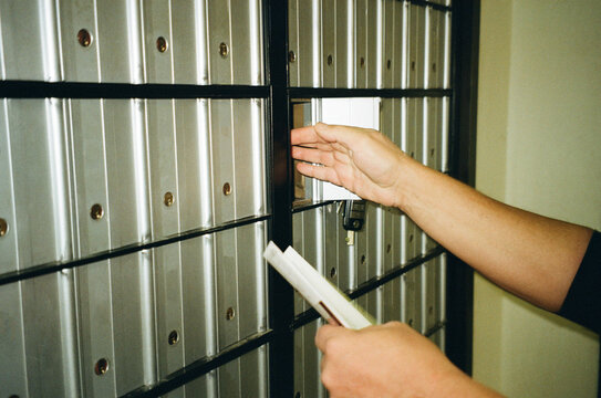 A man pulls mail out of a post office box