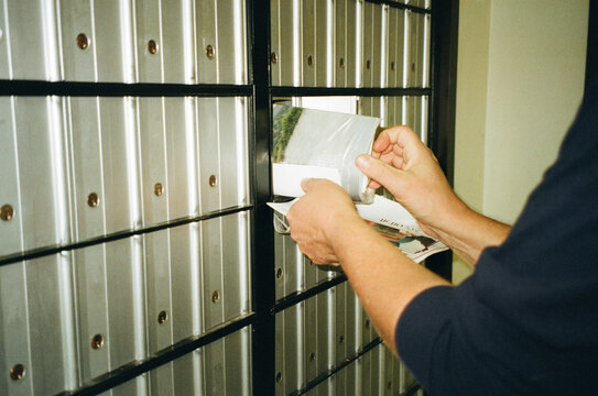 A man pulls mail out of a mailbox