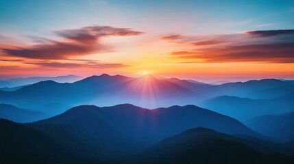 A breathtaking sunrise casts vibrant colors over misty mountains, creating a serene and tranquil landscape.