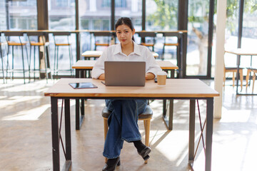 Asian Business woman doing on laptop math finance on an office desk, tax, report, accounting, statistics, and analytical research concept
