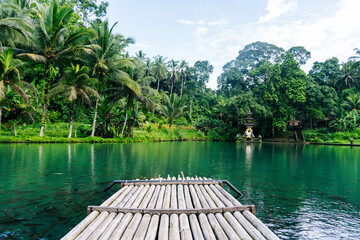 Bamboo raft floating on the lake with hindu temple in Bali, Indonesia
