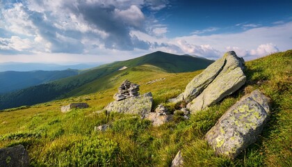 Fototapeta premium stones and rocks on the slope of alpine meadow vacation season summer mountain landscape with cloudy sky grassy hill top in the distant background smooth alps of transcarpathia