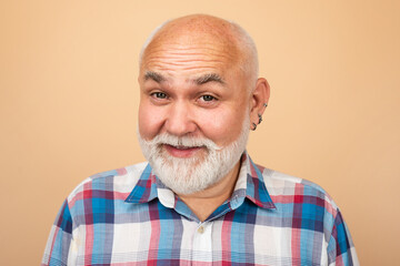 Fototapeta premium Happy and surprised old mature man face. Close-up studio portrait of senior man looking at camera. Bearded old aged man, head and shoulders portrait.