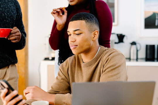 Diverse man spends some leisure time using his mobile phone at work