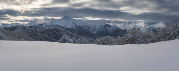Snow-Covered mountains under a cloudy winter sky