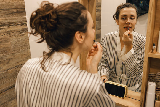 Portrait of a woman looking to video tutorial to put on makeup

