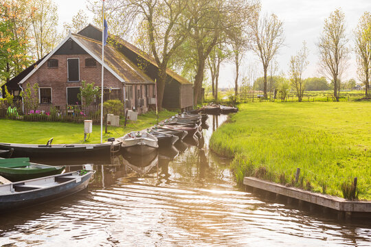 Tranquil Dutch Farmhouse with Boats at Golden Hour Giethoorn Scene.