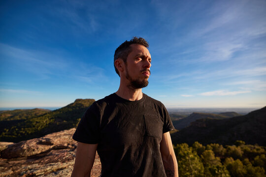 Thoughtful man standing on top of mountain