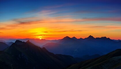 large panorama landscape image of mountains at sunset with colorful vibrant sky and silhouetted mountain range