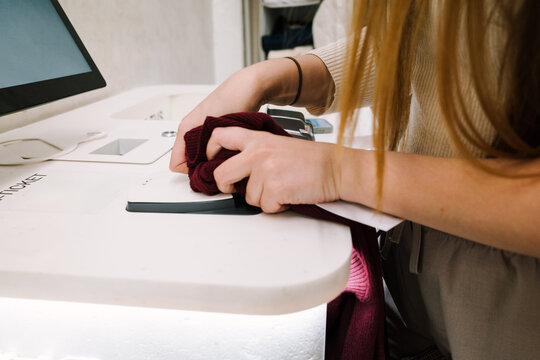  Woman Removing Alarm from Sweater
