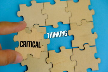 Fototapeta premium Critical Thinking concept on wooden block over blue background.