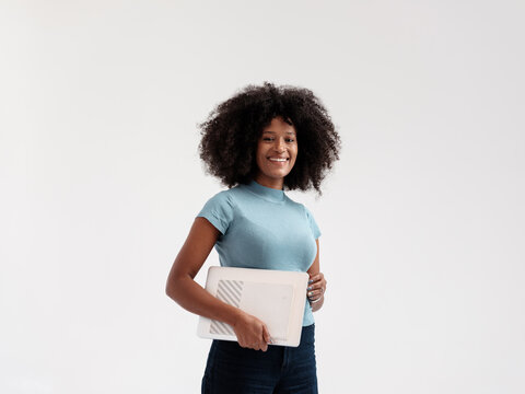 Confident Woman Holding a Laptop in Studio Setting