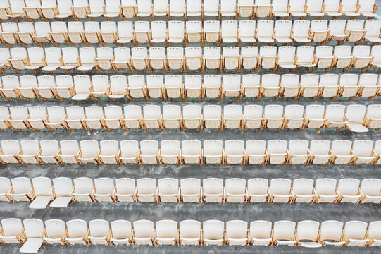 Neatly Arranged White Folding Chairs in an Empty Venue