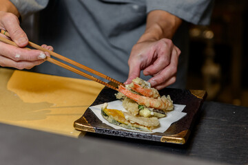 天ぷらを盛り付ける料理人の手元	