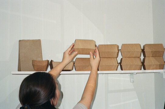 Owner organizing takeout containers in small cafe