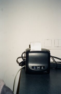 Cafe owner processing orders with receipt printer at local coffee shop